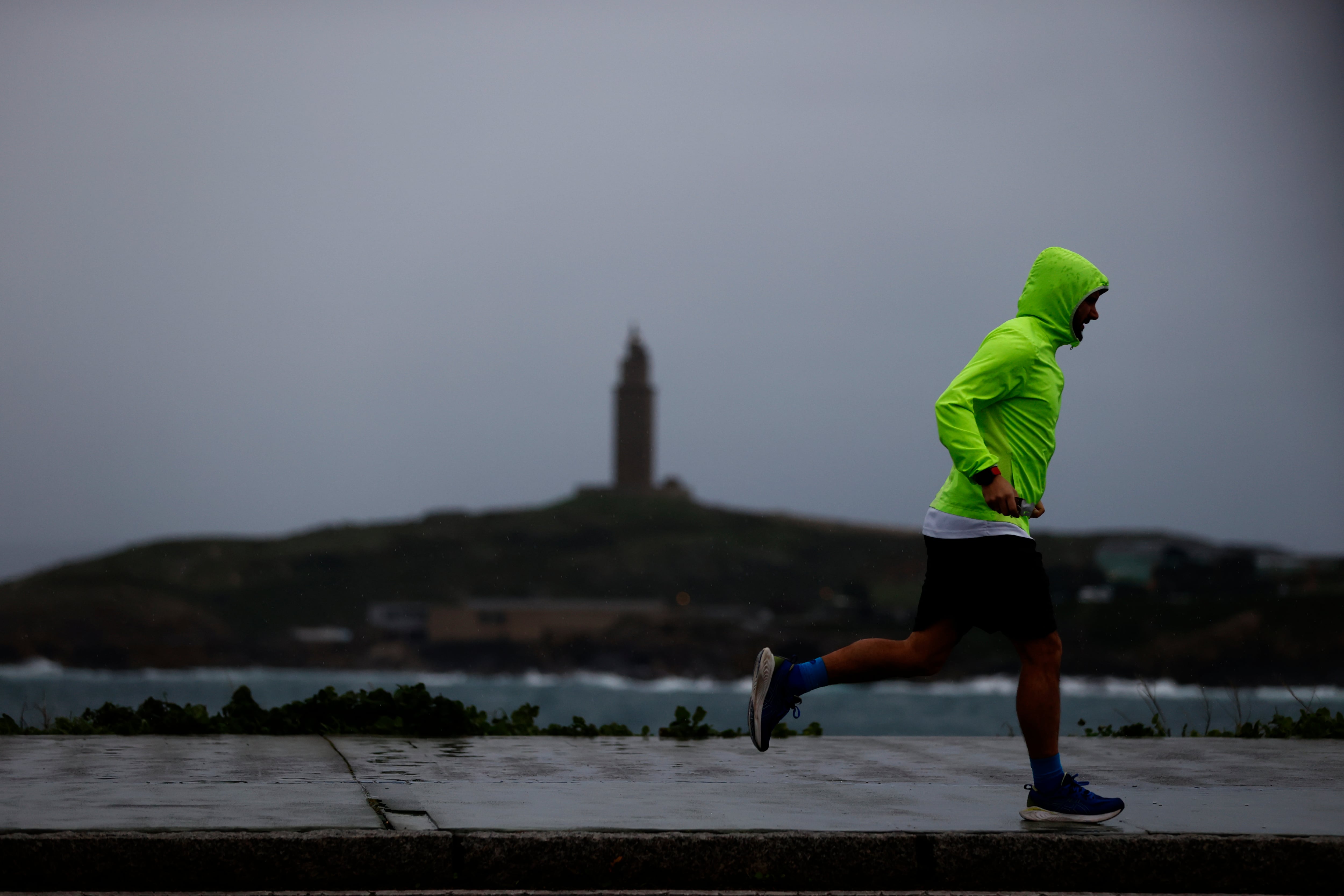 Un hombre practica deporte por el paseo marítimo de A Coruña