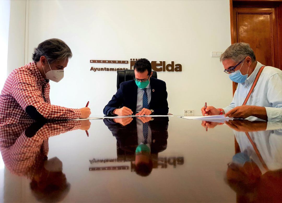 Manolo Pastor (I), Pte. del Elda Prestigio, firmando el convenio con el alcalde de Elda, Ruben Alfaro (C)