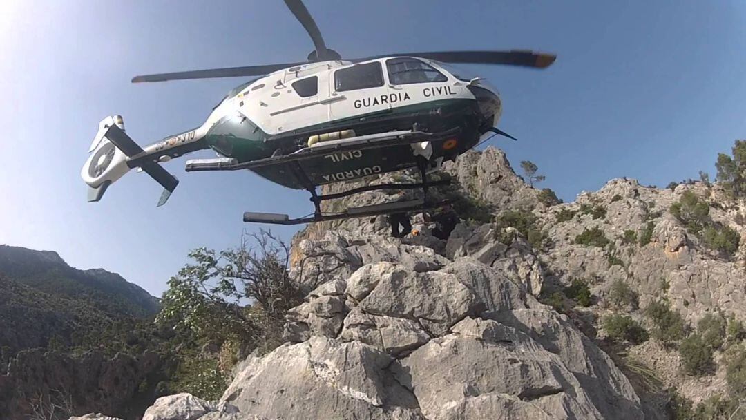 Un helicóptero de la Guardia Civil sobrevuela una zona montañosa.