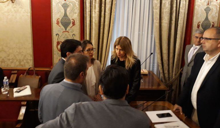 Eva Montesinos, (al fondo), conversa en un receso del pleno con los portavoces de los grupos, ante la mirada del edil Carlos Giménez.