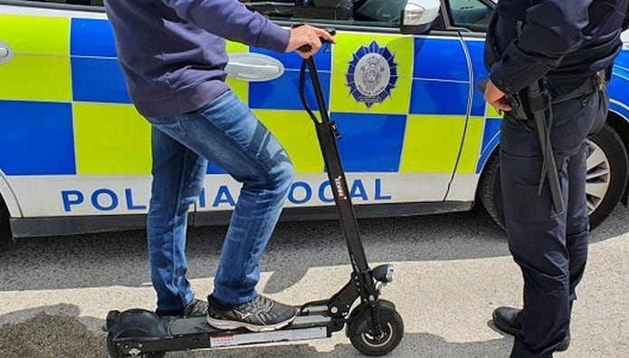 Un agente sanciona a un conductor de patinete