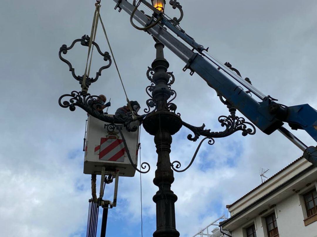 Operarios restaurando la farola