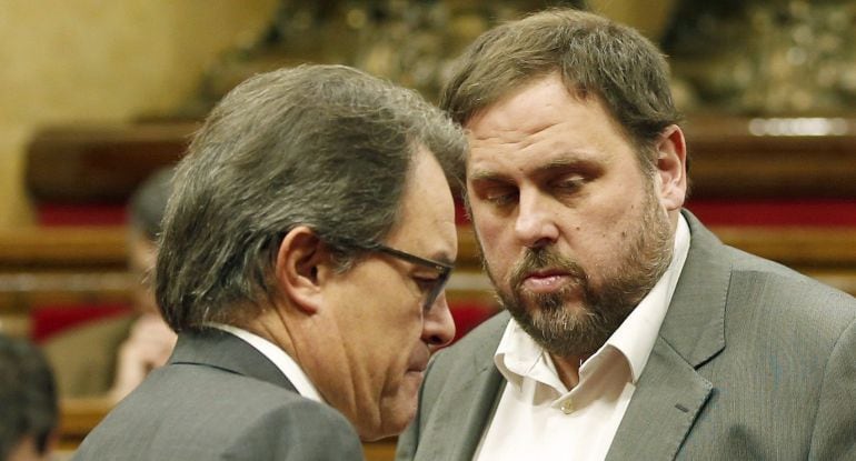 GRA089. BARCELONA, 19/12/2014.- El presidente de la Generalitat, Artur Mas (i) , y el líder de ERC, Oriol Junqueras (d), conversan en el hemiciclo tras la reunión que han mantenido en el despacho del presidente catalán en el Parlament. EFE/Andreu Dalmau