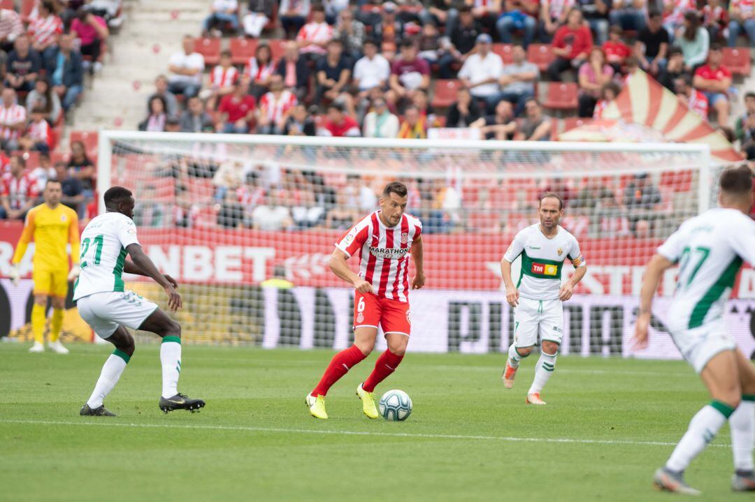 El capitán del Girona Granell, con el balón, rodeado de jugadores del Elche