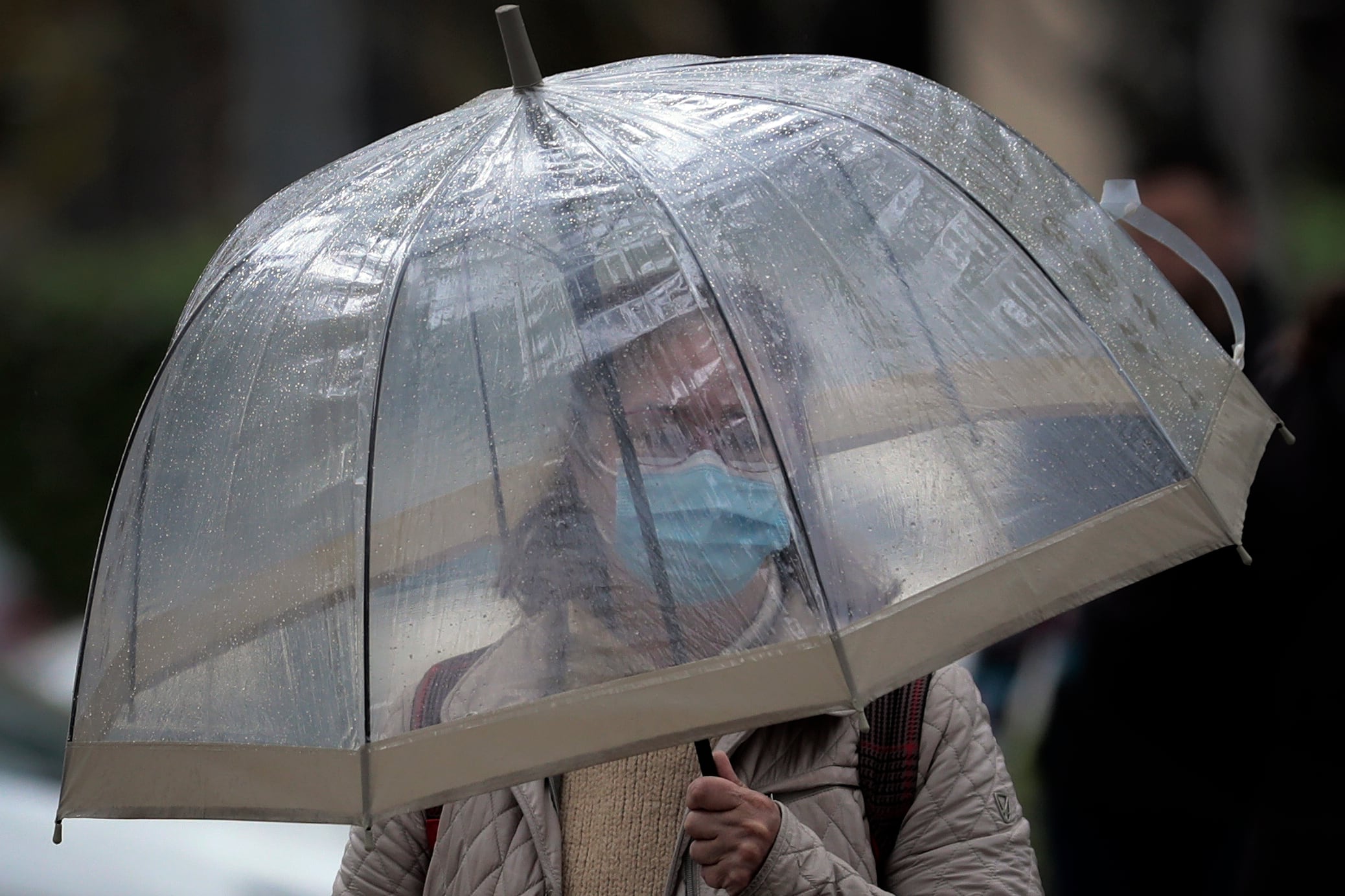 Una mujer se protege de la lluvia con un paraguas