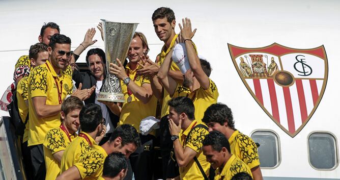 Los jugadores del Sevilla menean la copa a su aterrizaje en Sevilla