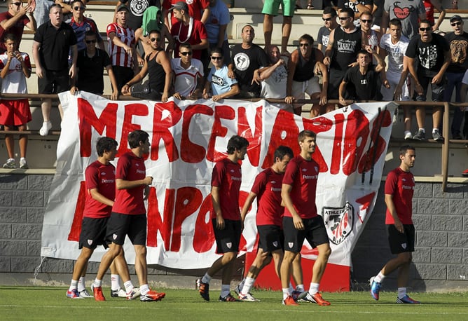 Los jugadores del Athletic, durante la sesión de entrenamiento en la que un grupo de seguidores radicales del equipo rojiblanco, han desplegado una pancarta con el lema &#039;Mercenarios Kanpora&#039; (mercenarios fuera) en alusión a los jugadores Javi Martinez y F