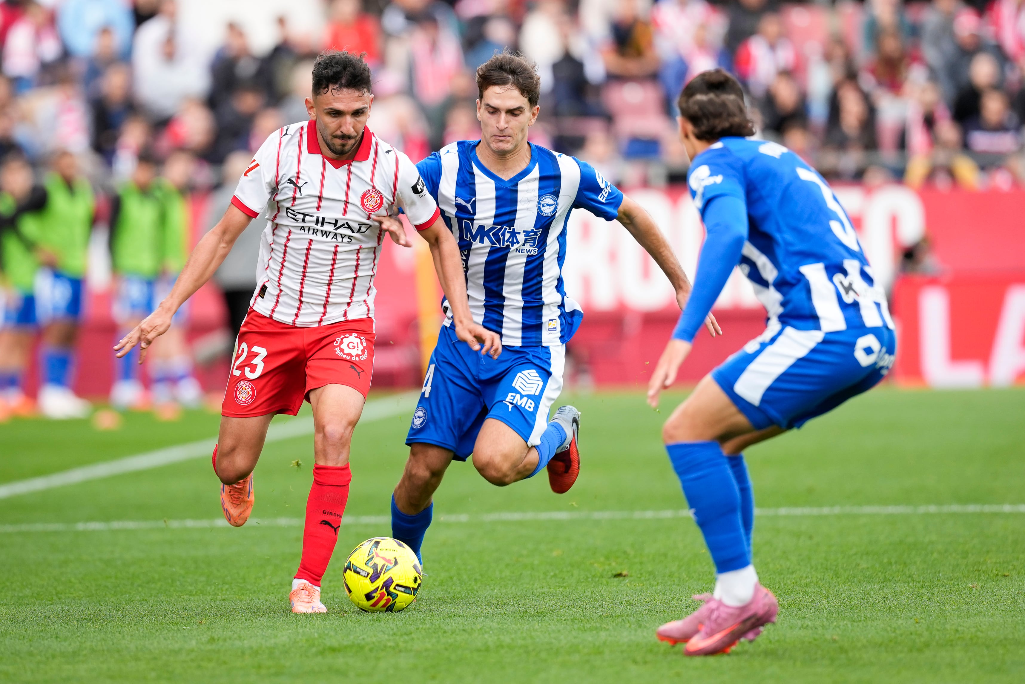 GIRONA, 08/11/2025.- Iván Martín (i) del Girona FC pelea un balón con Denis Suárez (c) del Alavés durante el partido de LaLiga EA Sports entre el Girona FC y el Alavés, este sábado en el estadio municipal de Montilivi. EFE/ David Borrat
