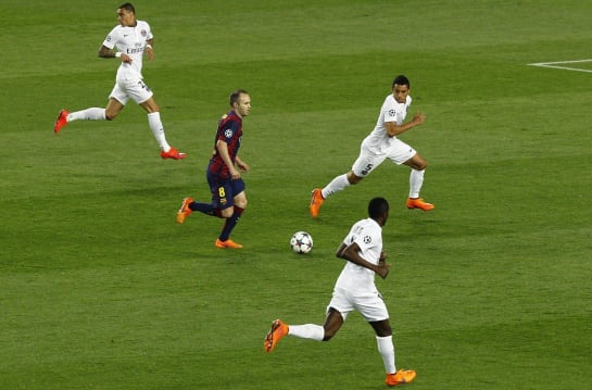 Barcelona&#039;s midfielder Andres Iniesta drives the ball through PSG defenders during the UEFA Champions League quarter-finals second leg football match FC Barcelona vs Paris Saint-Germain at the Camp Nou stadium in Barcelona on April 21, 2015. AFP PHOTO/ QU