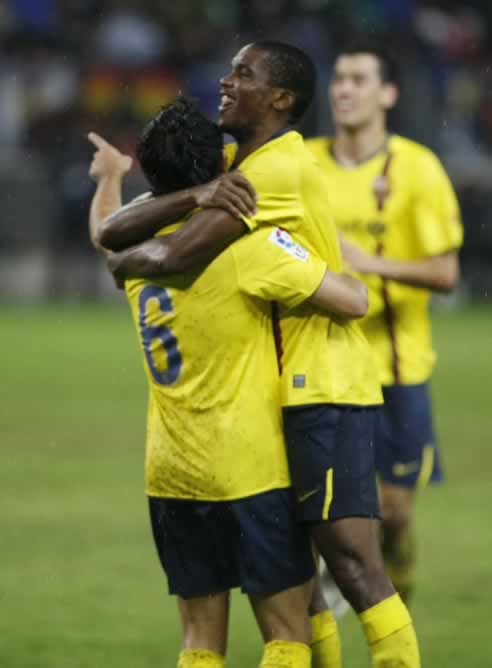 Xavi celebra uno de sus goles ante el Málaga con Eto'o
