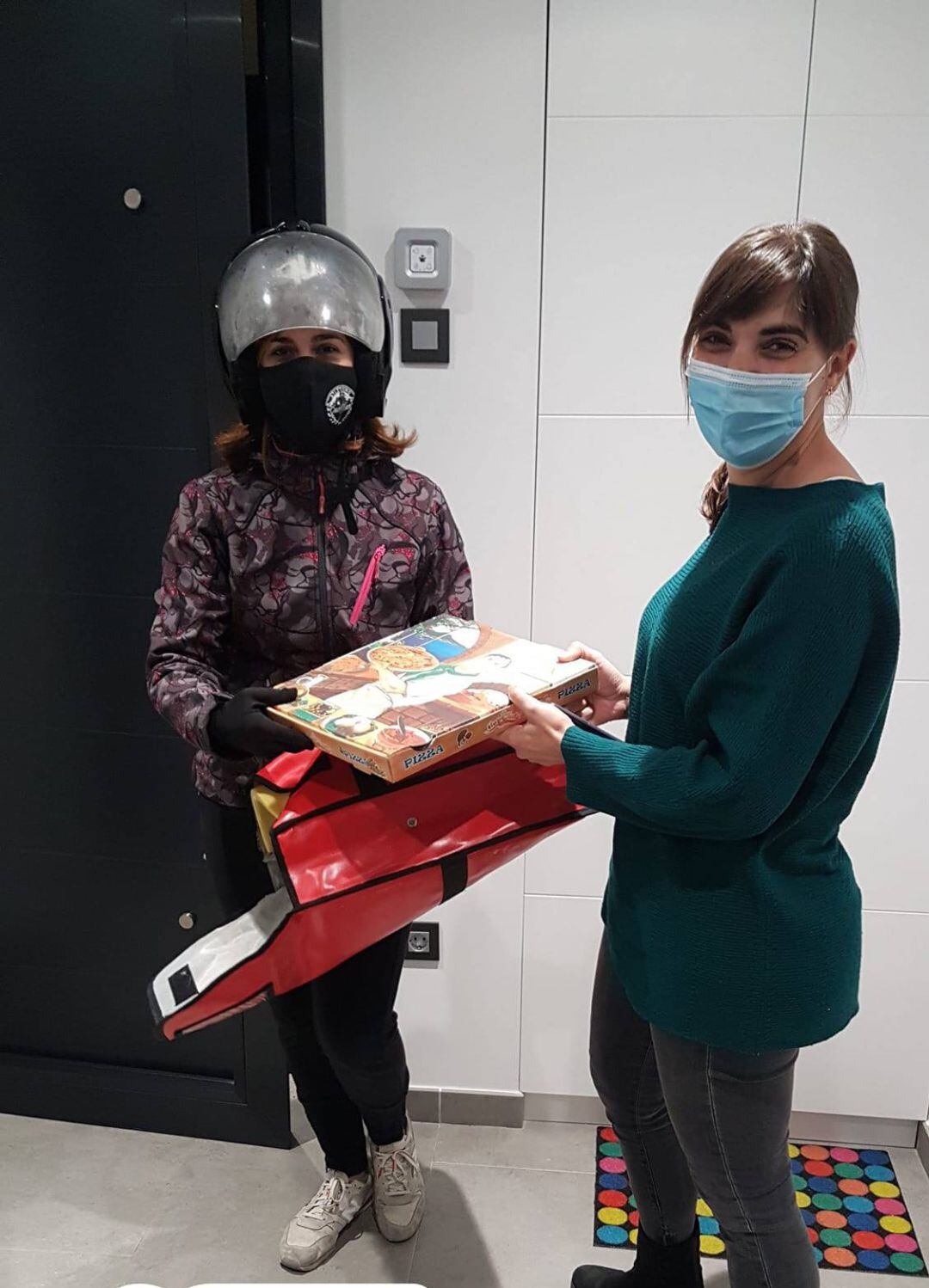 Lucía Arranz, con casco, entrega una pizza en casa de una vecina cuellarana