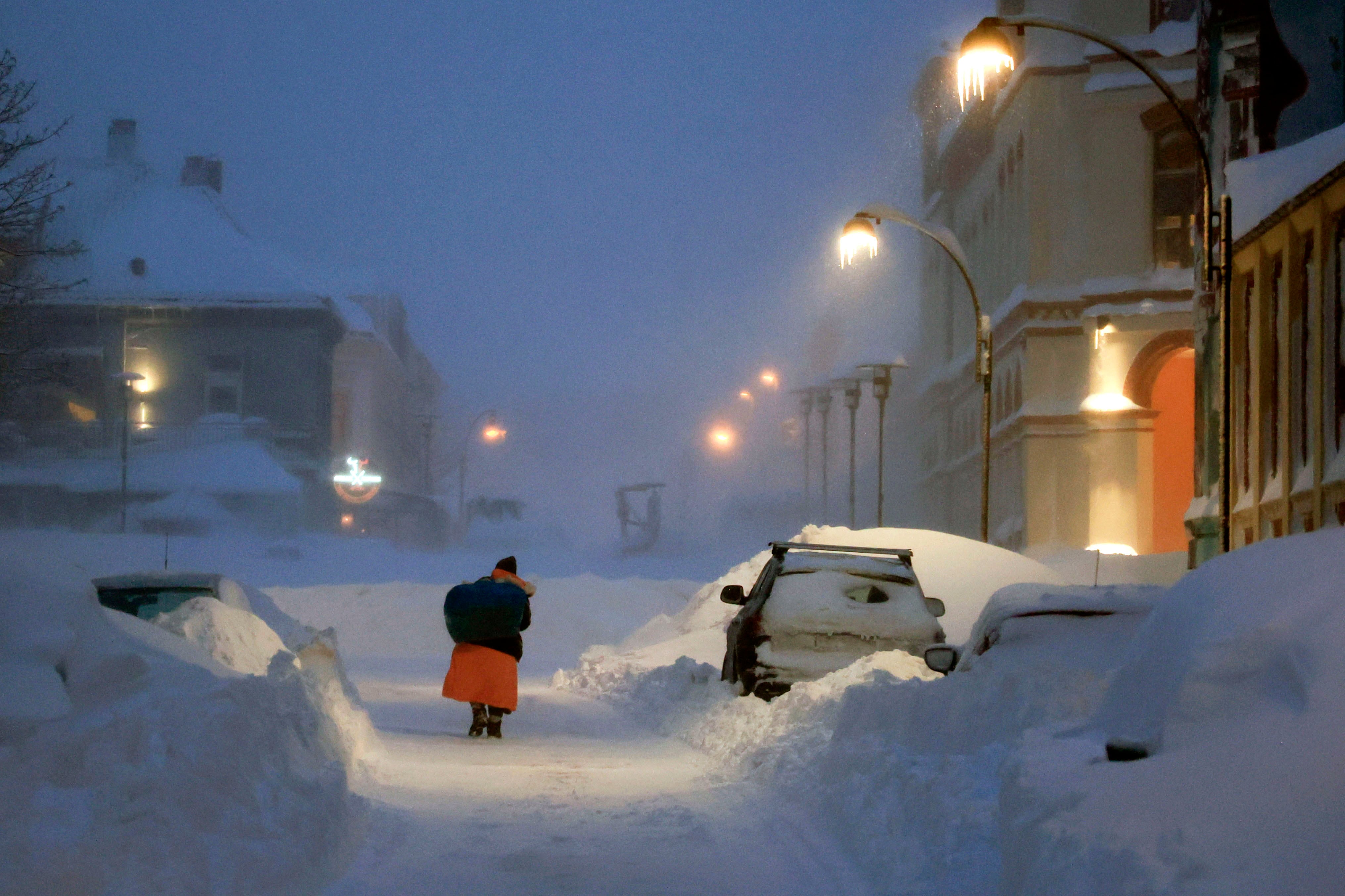 Una persona caminando bajo la nieve en la ciudad noruega de Kristiansand