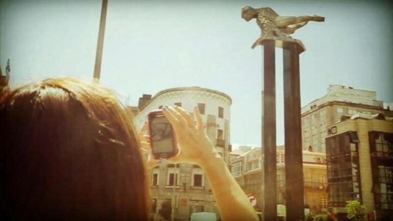 Una turista saca una fotografía al Sireno de Vigo