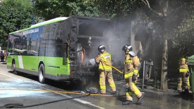 Los efectivos antiincendios intentan apagar el fuego en el autobús