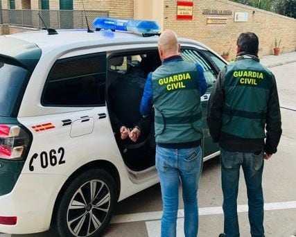 Uno de los jóvenes detenidos es trasladado en un coche de la Guardia Civil