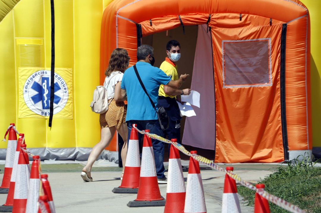 Varias personas entran en las carpas del SEM en Alcarràs (Lleida) para hacerse las pruebas PCR