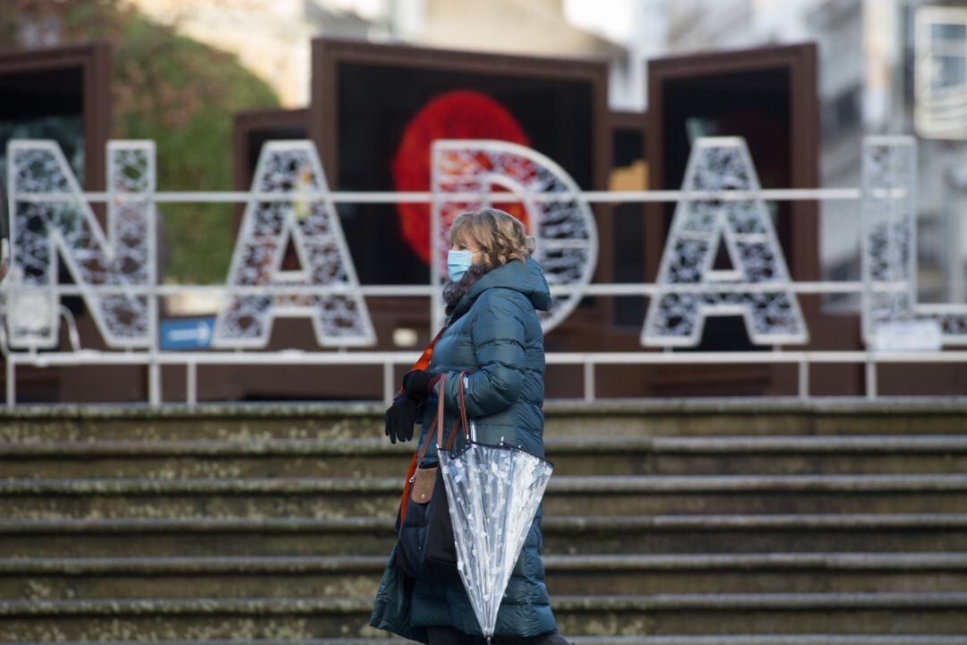 Una mujer pasa frente a un luminoso con la palabra Nadal en Lugo, tras el levantamiento del cierre perimetral de la ciudad, en Lugo, Galicia (España), a 30 de diciembre de 2020.  