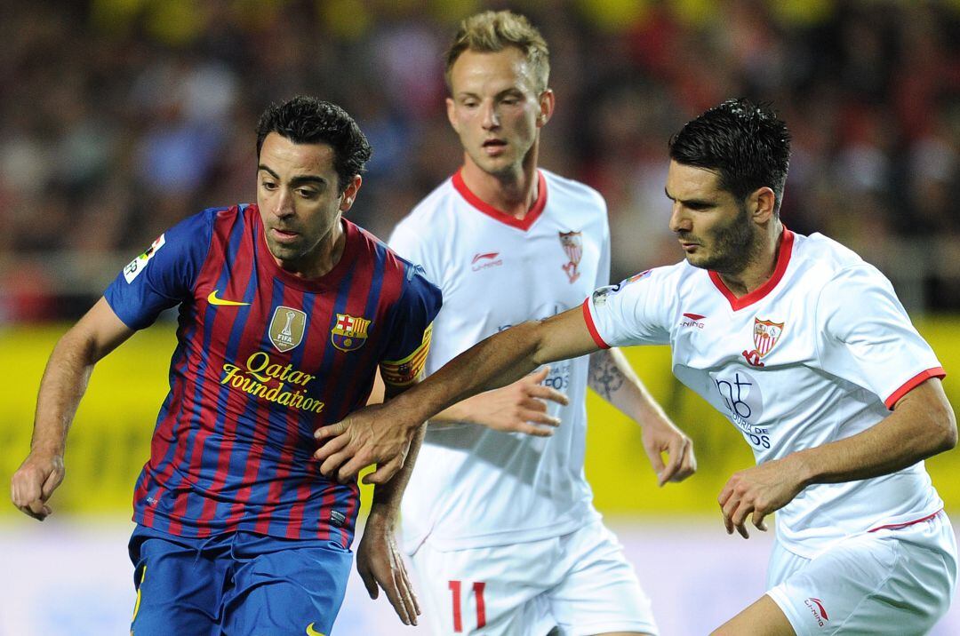 Emir Spahic, junto a Xavi Hernández e Ivan Rakitic durante un partido con el Sevilla