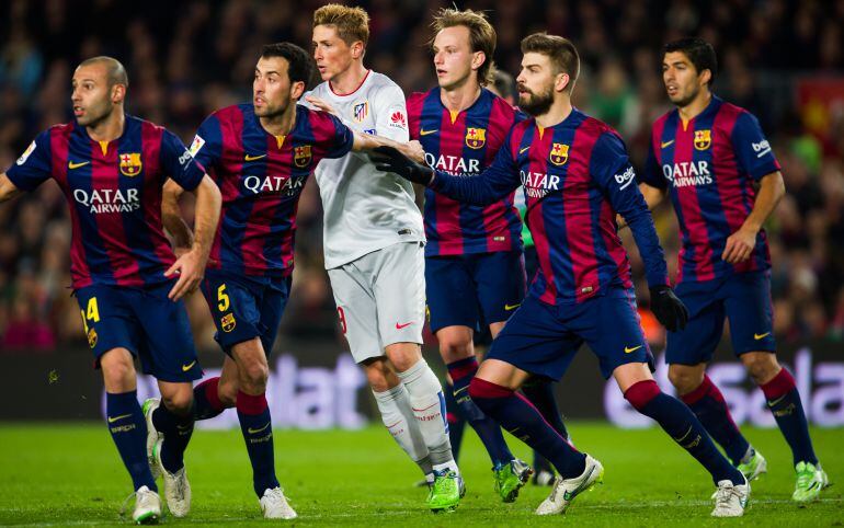 Fernando Torres, entre los jugadores del Barcelona en el último Barça - Atlético de la Liga.