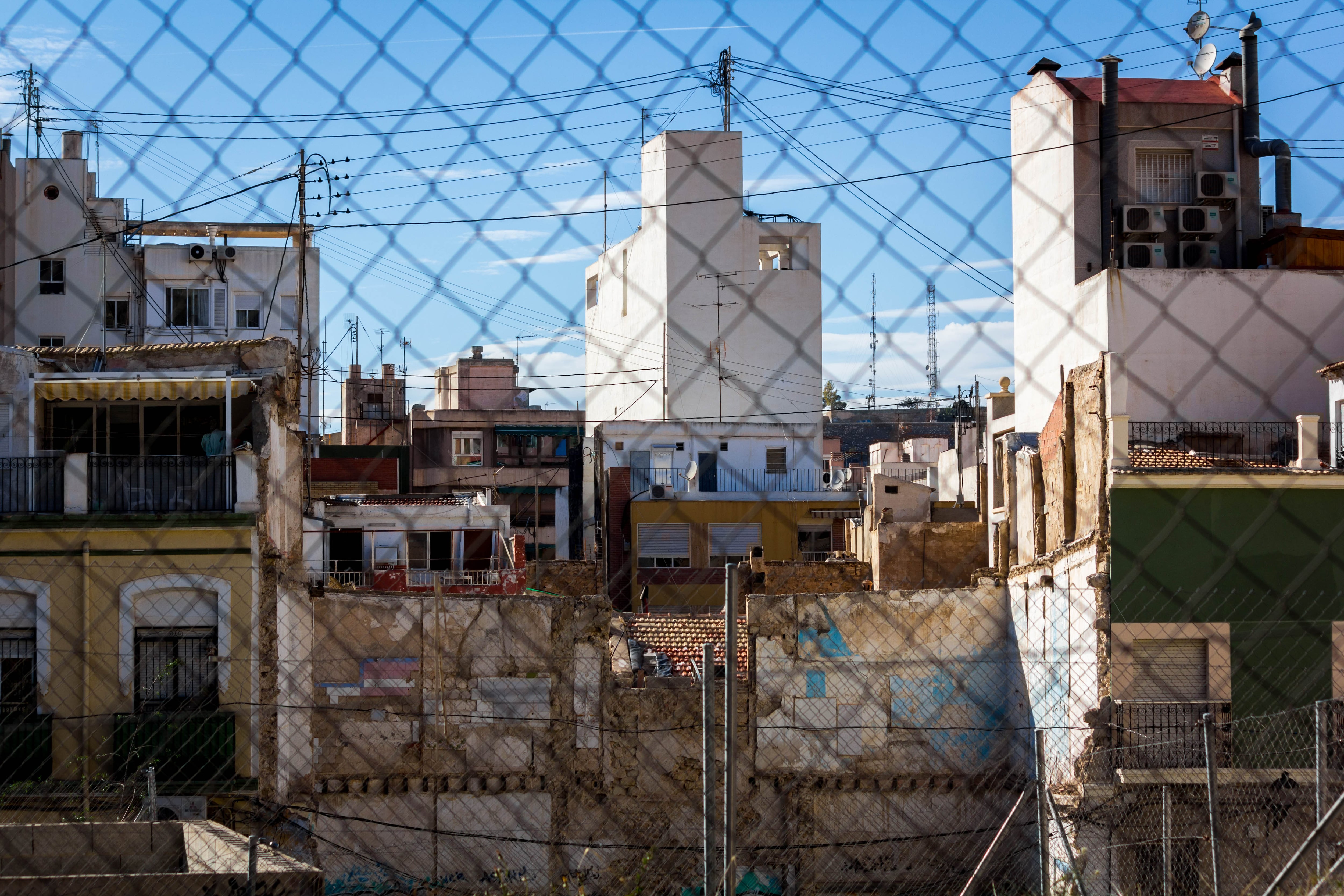 Casas antiguas detrás de una valla metálica en Alicante