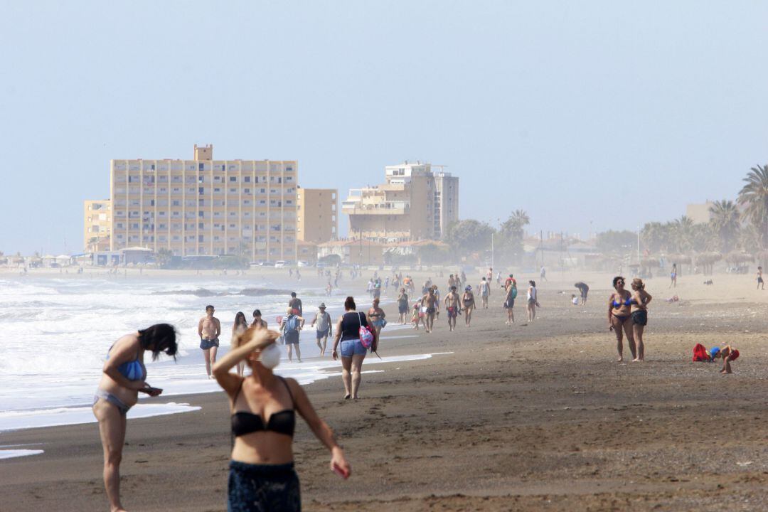 Paseantes disfrutan de la playa de Huelín