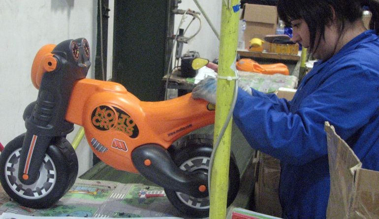 Una dona treballant en una fàbrica.