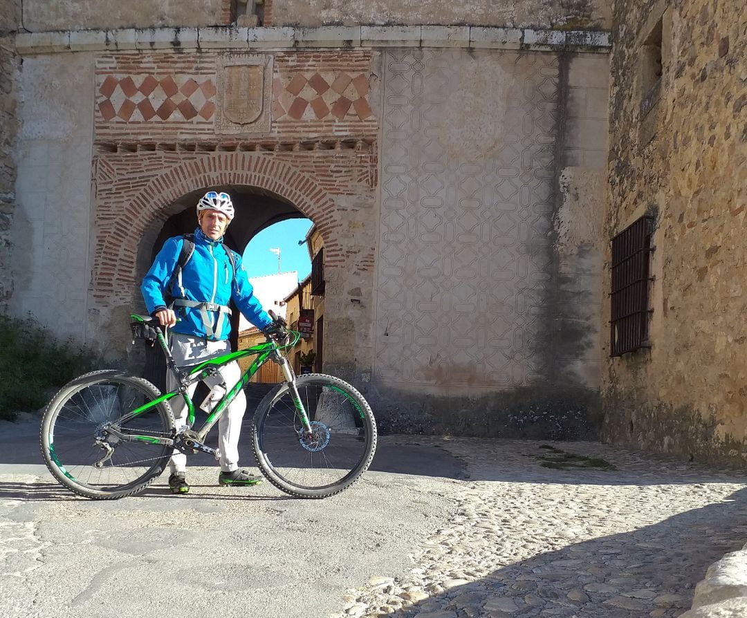 Javier Carracedo con su bicicleta en la entrada de la localidad de Pedraza