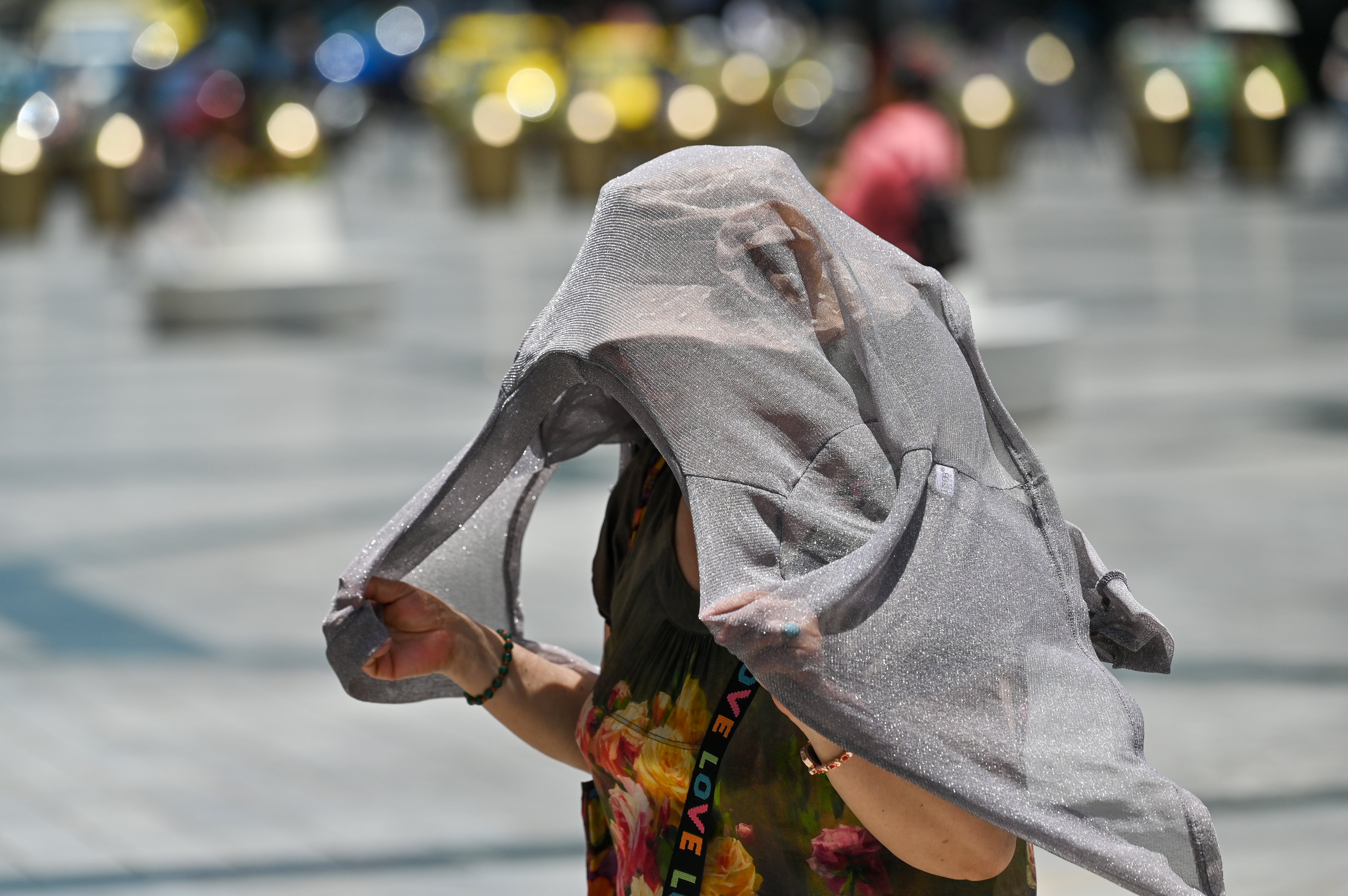 Una mujer se protege del calor en la ciudad china de Chongqing