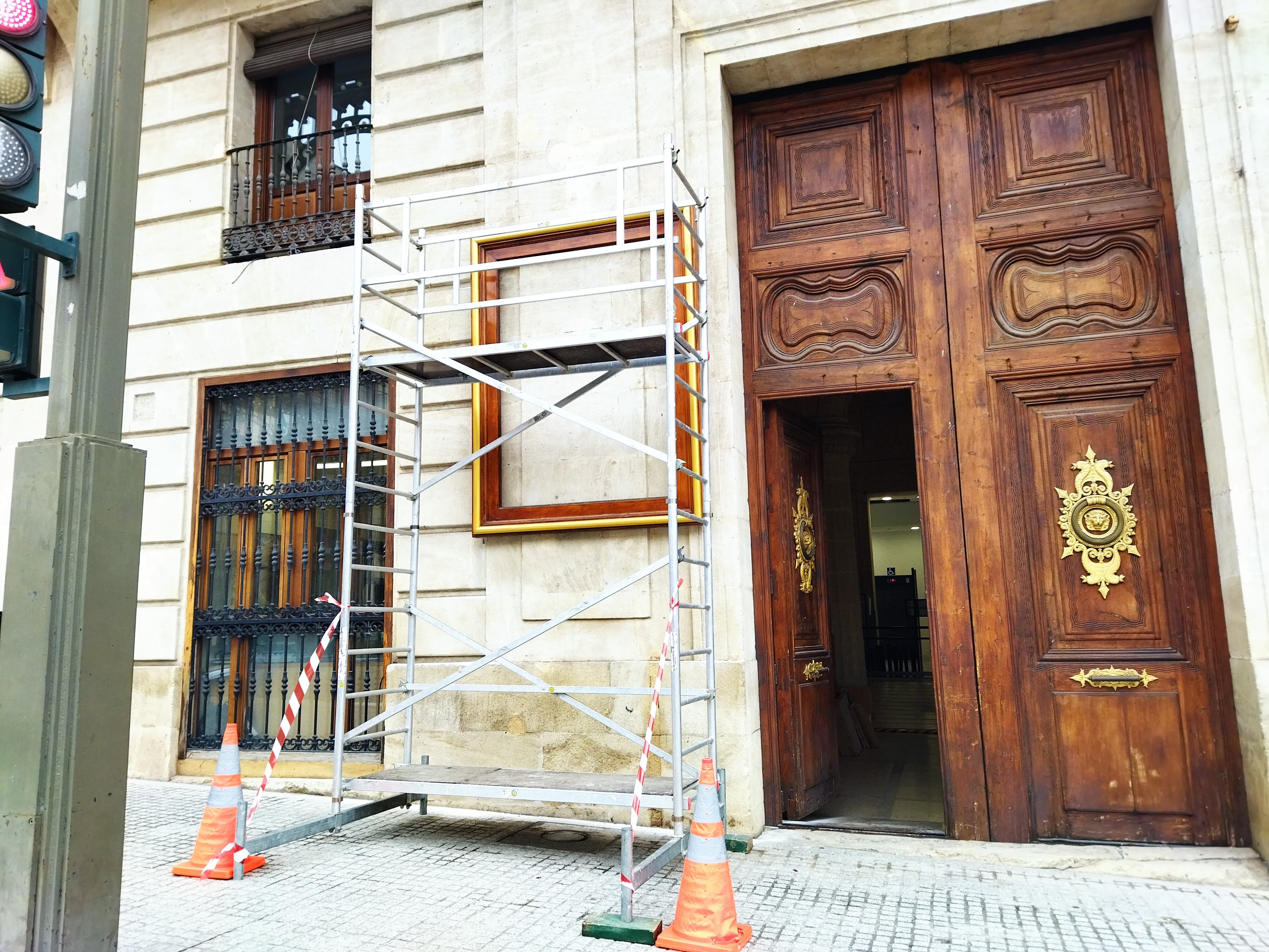 Preinstalación del soporte del cartel de fiestas de Alcoy al otro lado de la puerta