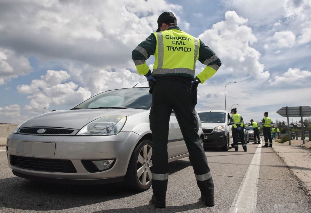 Un guardia civil da el alto a un vehículo en el punto kilométrico 19 de la A6 a su paso por la capital para regular el flujo del tráfico y si todos aquellos desplazamientos están justificados.