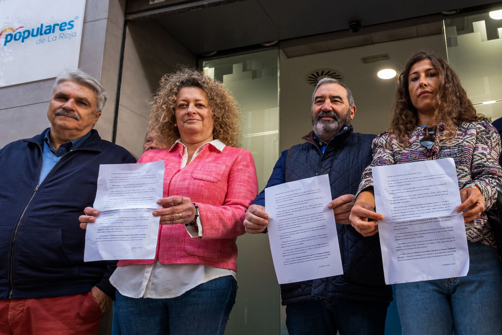 LOGROÑO, 05/10/2022.- Una de la portavoces de la plataforma, Almudena Rueda (2i) junto con sus compañeros muestra un escrito sobre la situación del PP de La Rioja en el que han pedido este miércoles al presidente nacional del partido, Alberto Núñez Feijóo, la convocatoria de un congreso asambleario porque &quot;los afiliados no nos merecemos que se nos imponga un candidato&quot;. EFE/Abel Alonso
