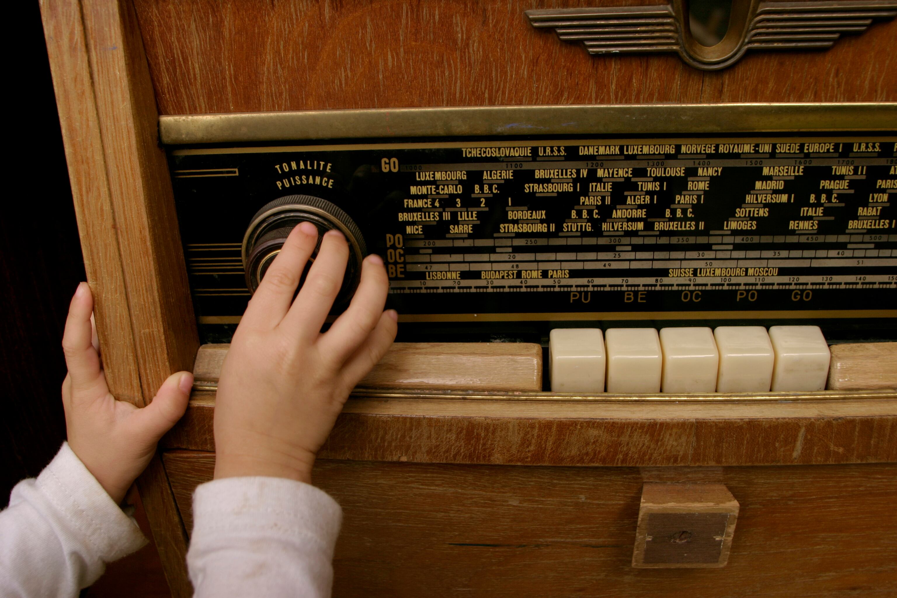 Un niño enciende una radio antigua. Archivo.