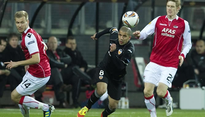 Los jugadores del AZ Alkmaar Ragner Klavan (izda) y Rasmus Elm, pelean por el control del balón con el jugador del Valencia Sofiane Feghouli