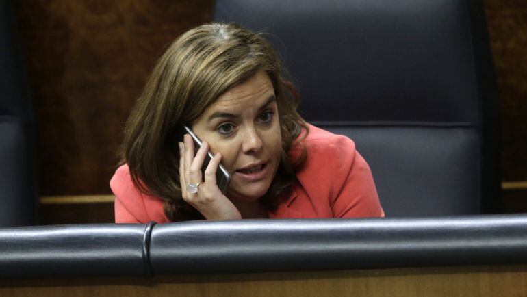 La vicepresidenta del Gobierno, Soraya Sáenz de Santamaría, habla por su teléfono móvil durante un pleno del Congreso