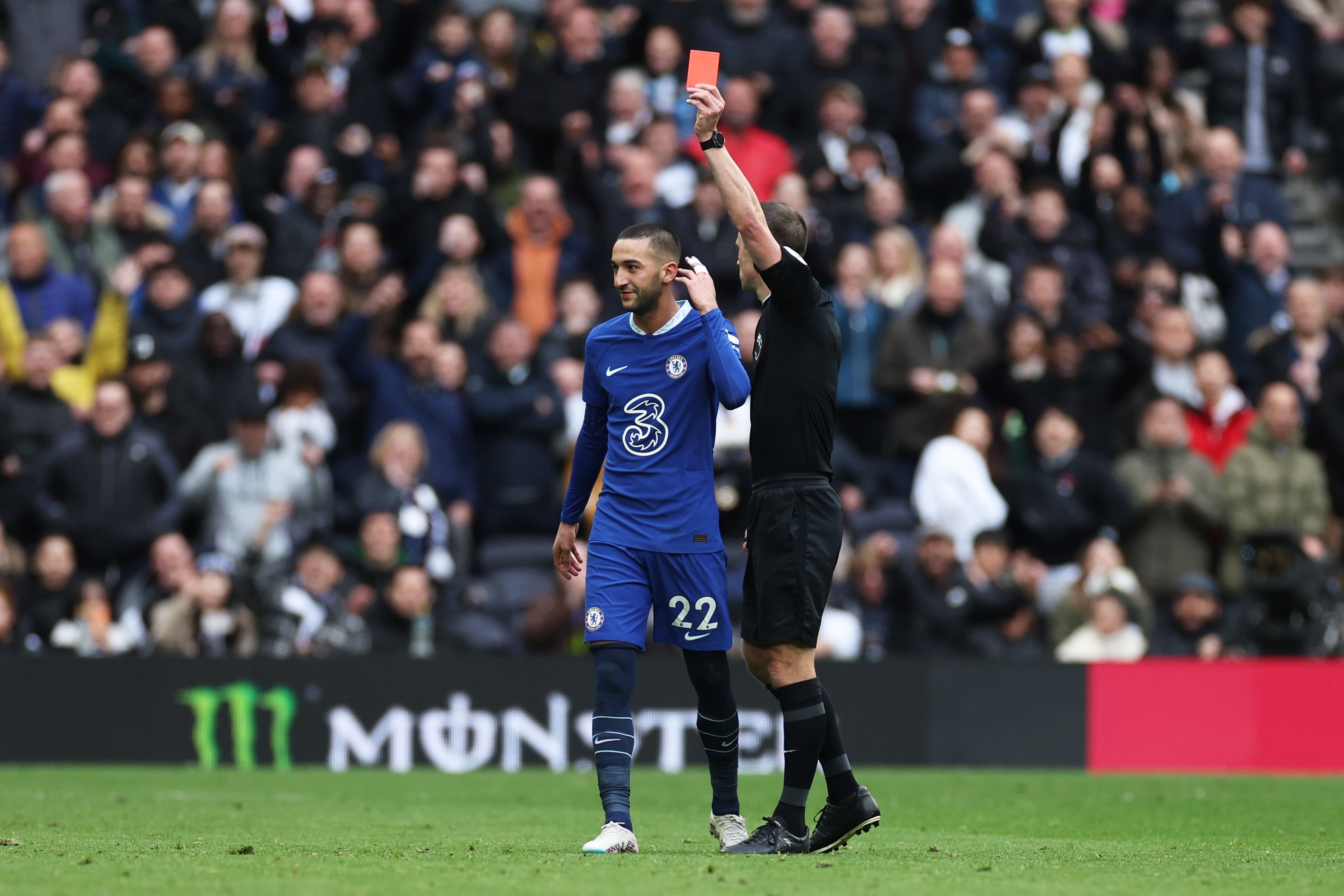 Stuart Attwell, árbitro del partido entre Tottenham y Chelsea, muestra la tarjeta roja a Hakim Ziyech por su manotazo a Emerson Royal