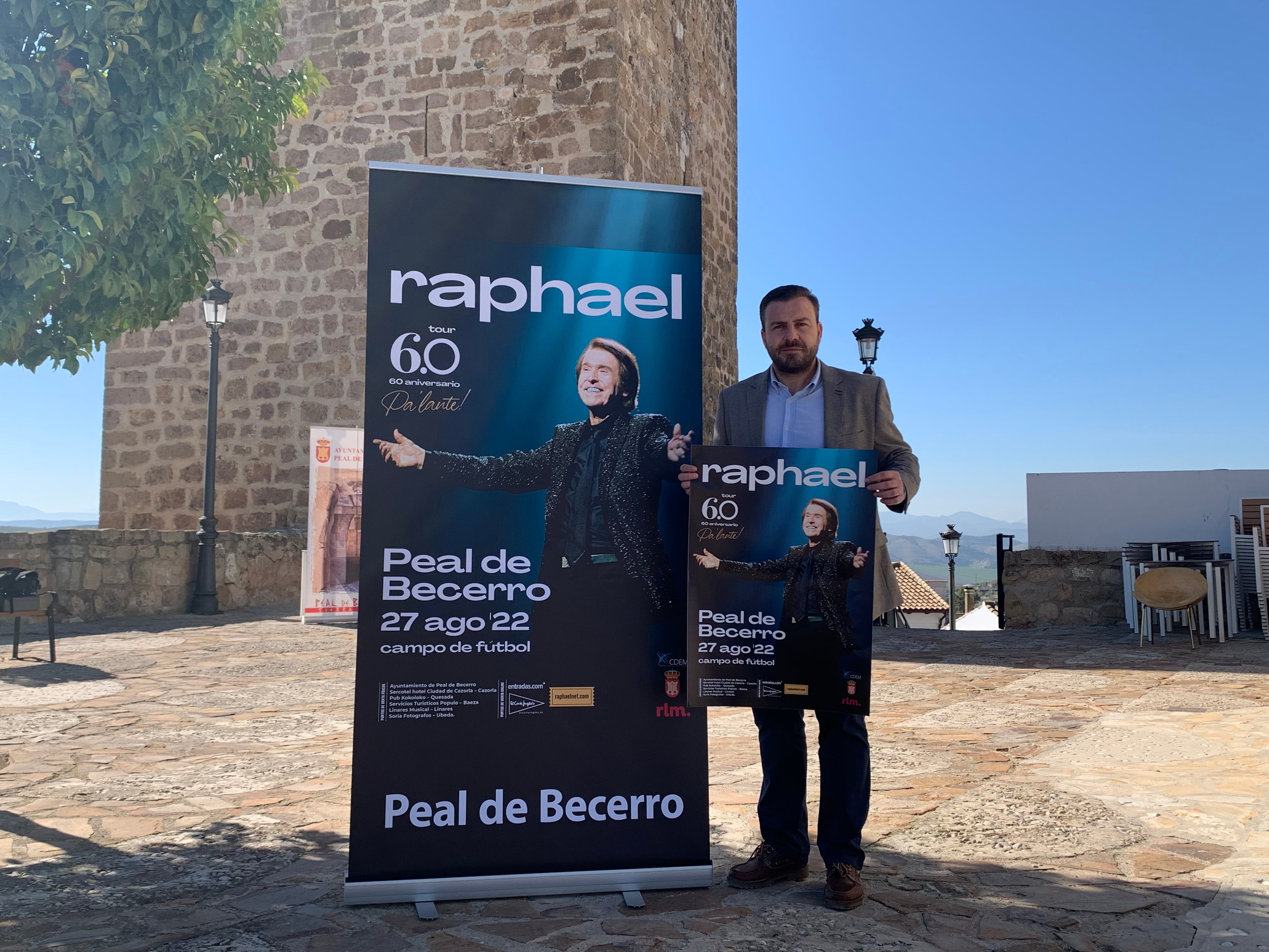 David Rodríguez, alcalde de Peal de Becerro, posa junto al cartel anunciador del concierto de Raphael