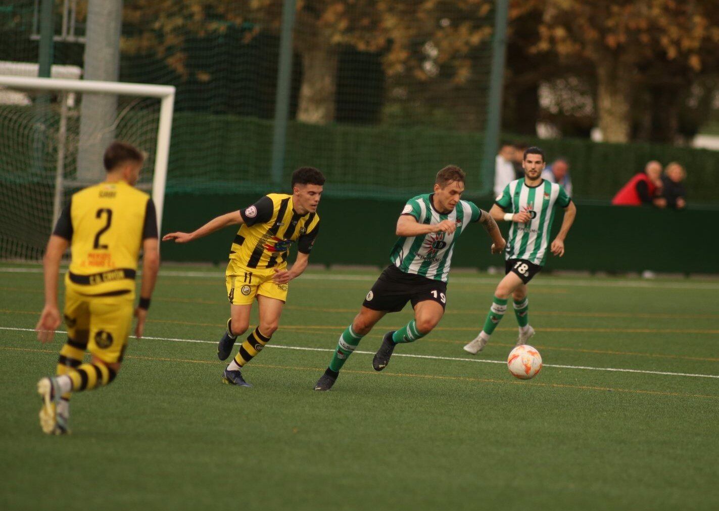 Vitali (Vimenor) conduce el balón ante la presencia de Jesús Laredo (Cayón)