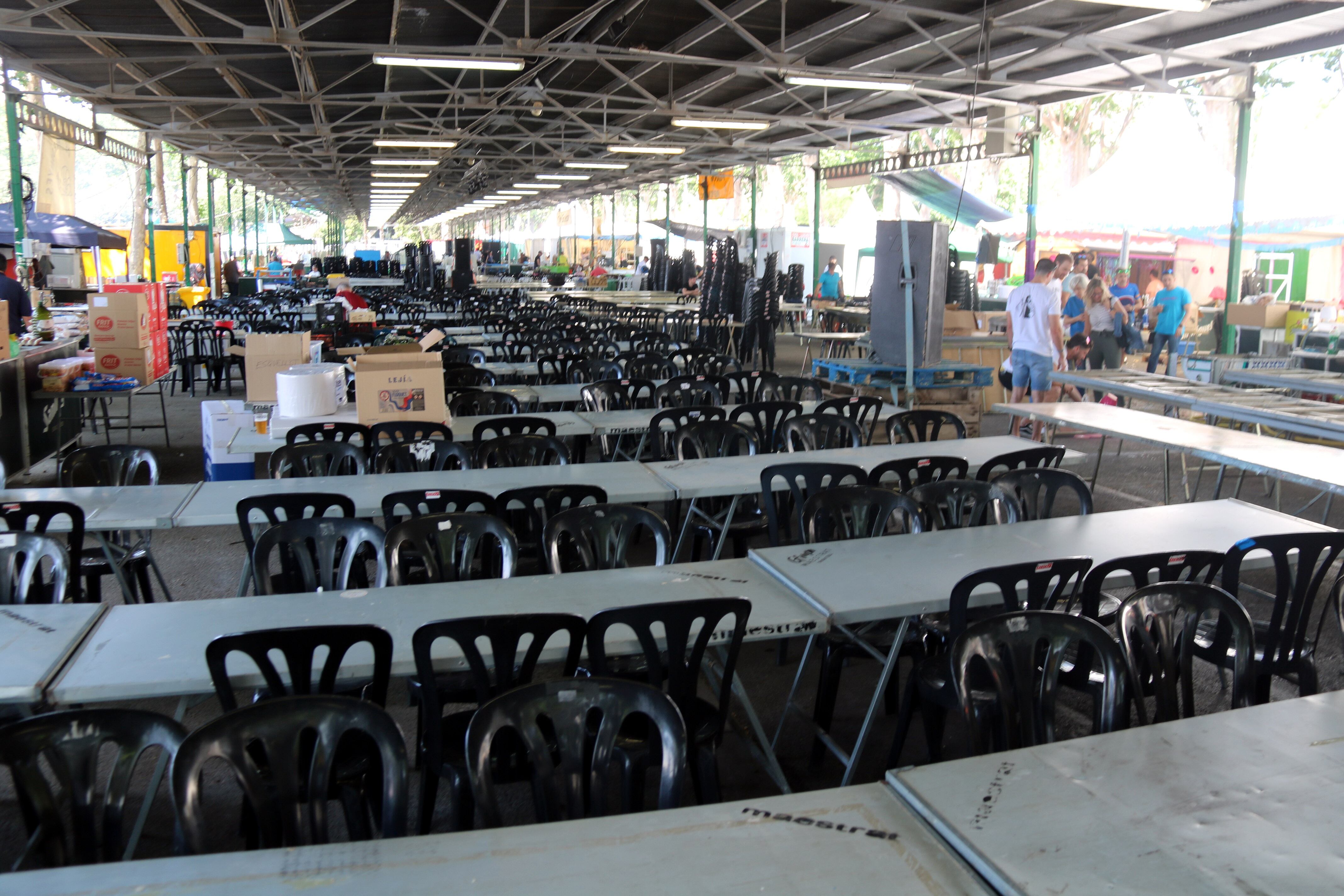 Una de les carpes amb les taules i les cadires de l'Aplec de 2023 a punt per a tres dies de festa i gastronomia. Foto: ACN