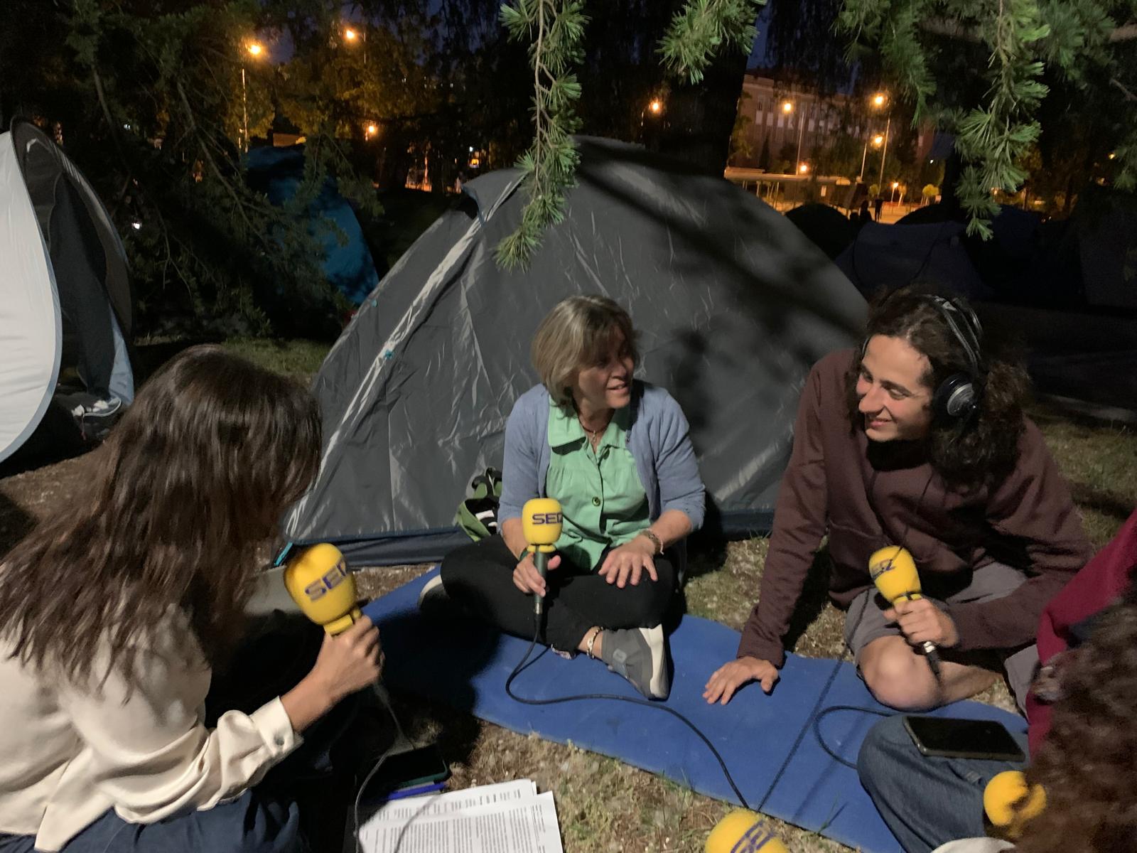 Mara Torres charla con Emma, Lucía, y Daniel, tres de los estudiantes acampados en la Complutense.