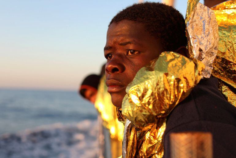 A migrant, covered with a thermal blanket, gazes at the sea aboard the former fishing trawler Golfo Azzurro of the Spanish NGO Proactiva Open Arms following a rescue operation near the coasts of Libya in the central Mediterranean Sea.