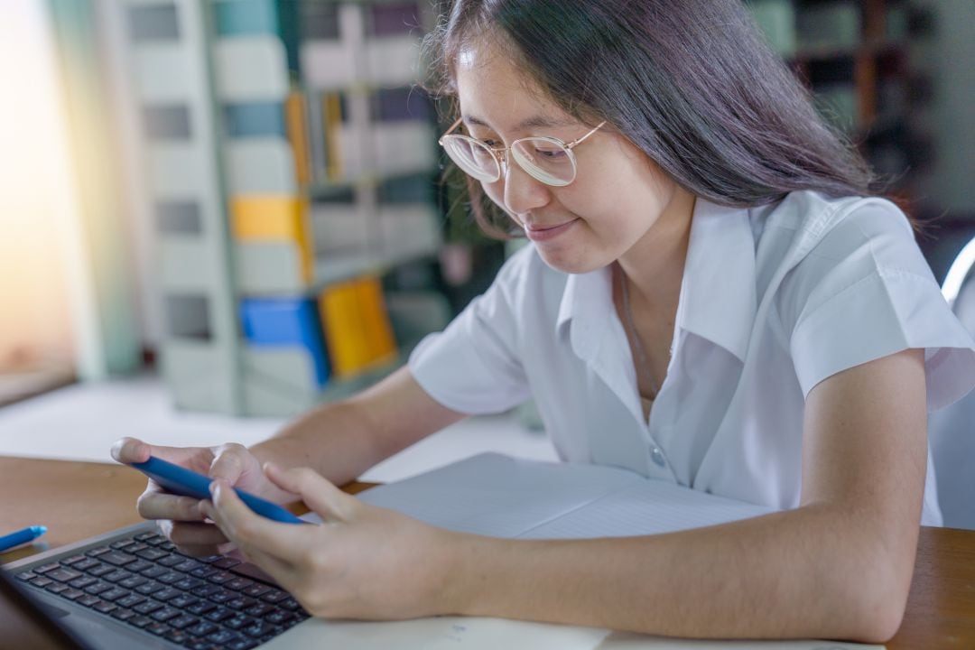 Una estudiante universitaria tailandesa, haciendo los deberes en una biblioteca pública.