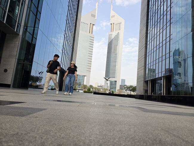 DUBAI (Emiratos Árabes Unidos), 02/03/2026.- Gente camina cerca de la puerta principal del Dubai International Financial Centre (DIFC).