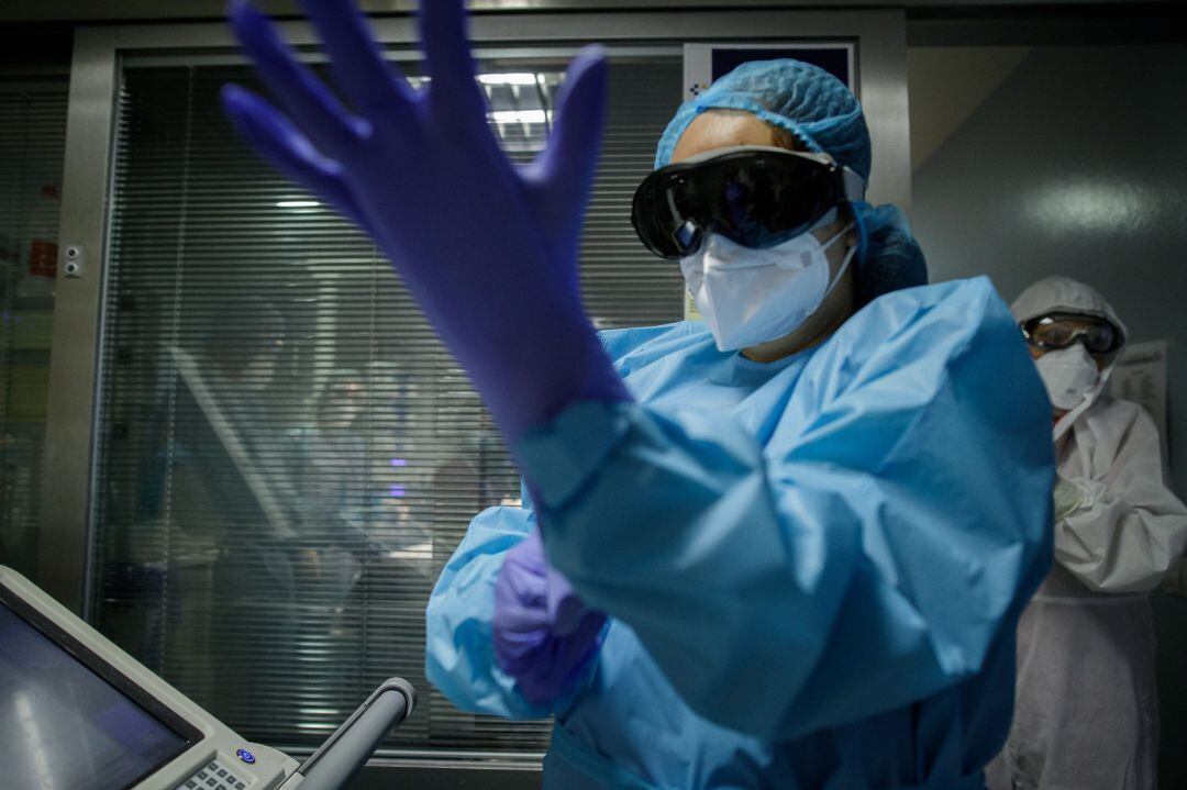 Personal sanitario colocándose los guantes antes de comenzar su trabajo. 