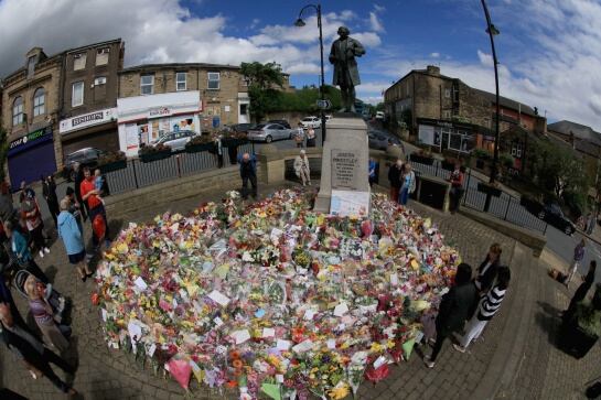 BIRSTALL, ENGLAND - JUNE 20: People view the growing carpet of floral tributes left in memory of slain Labour MP Jo Cox in Market Square, Birstall on June 20, 2016 in Birstall, United Kingdom. The Labour MP for Batley and Spen was about to hold her weekly