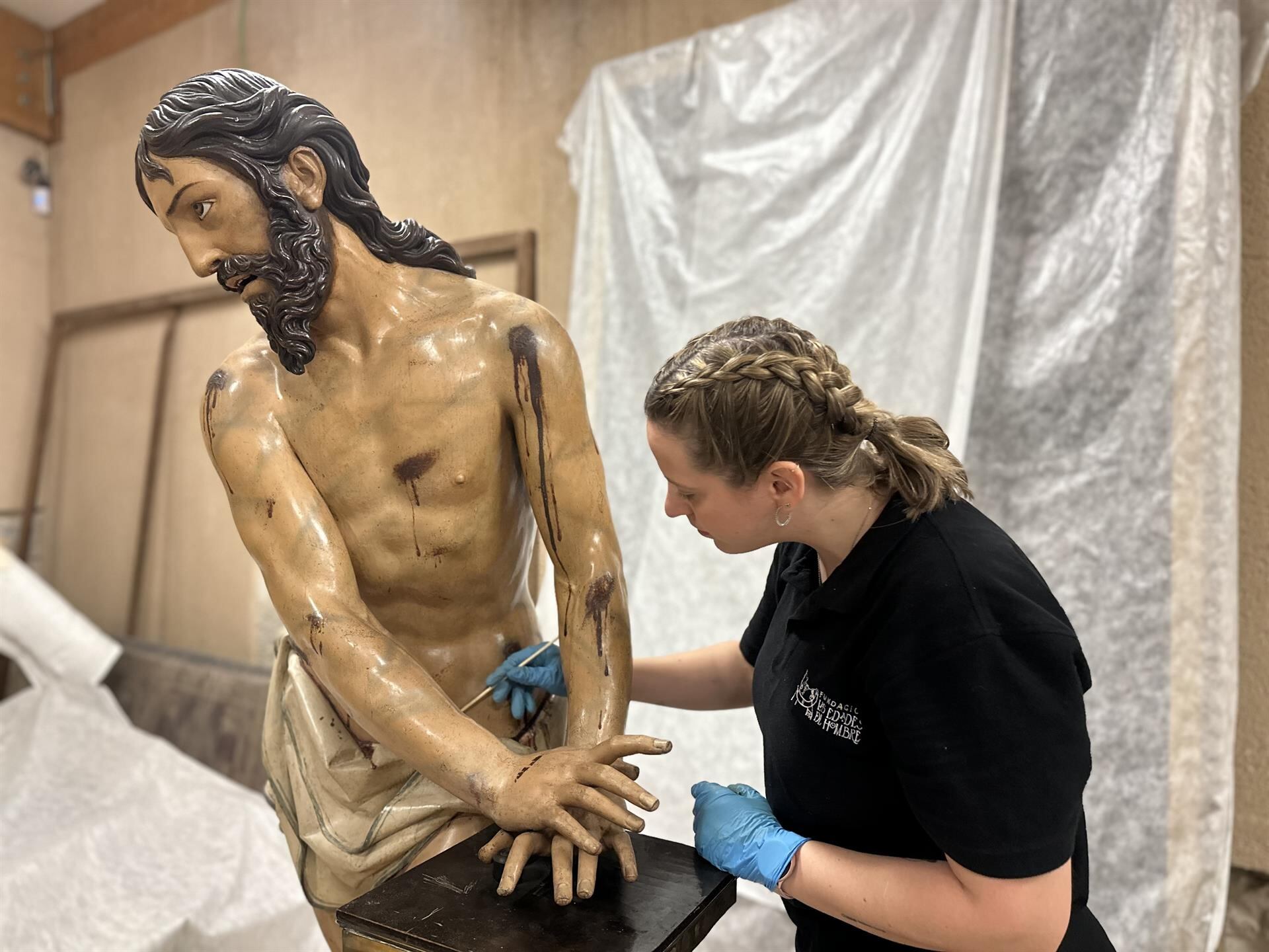 Una de las profesionales del Centro de Restauración y Conservación de la Fundación de las Edades del Hombre realiza labores de limpieza en &#039;El Señor Atado a la Columna&#039;.