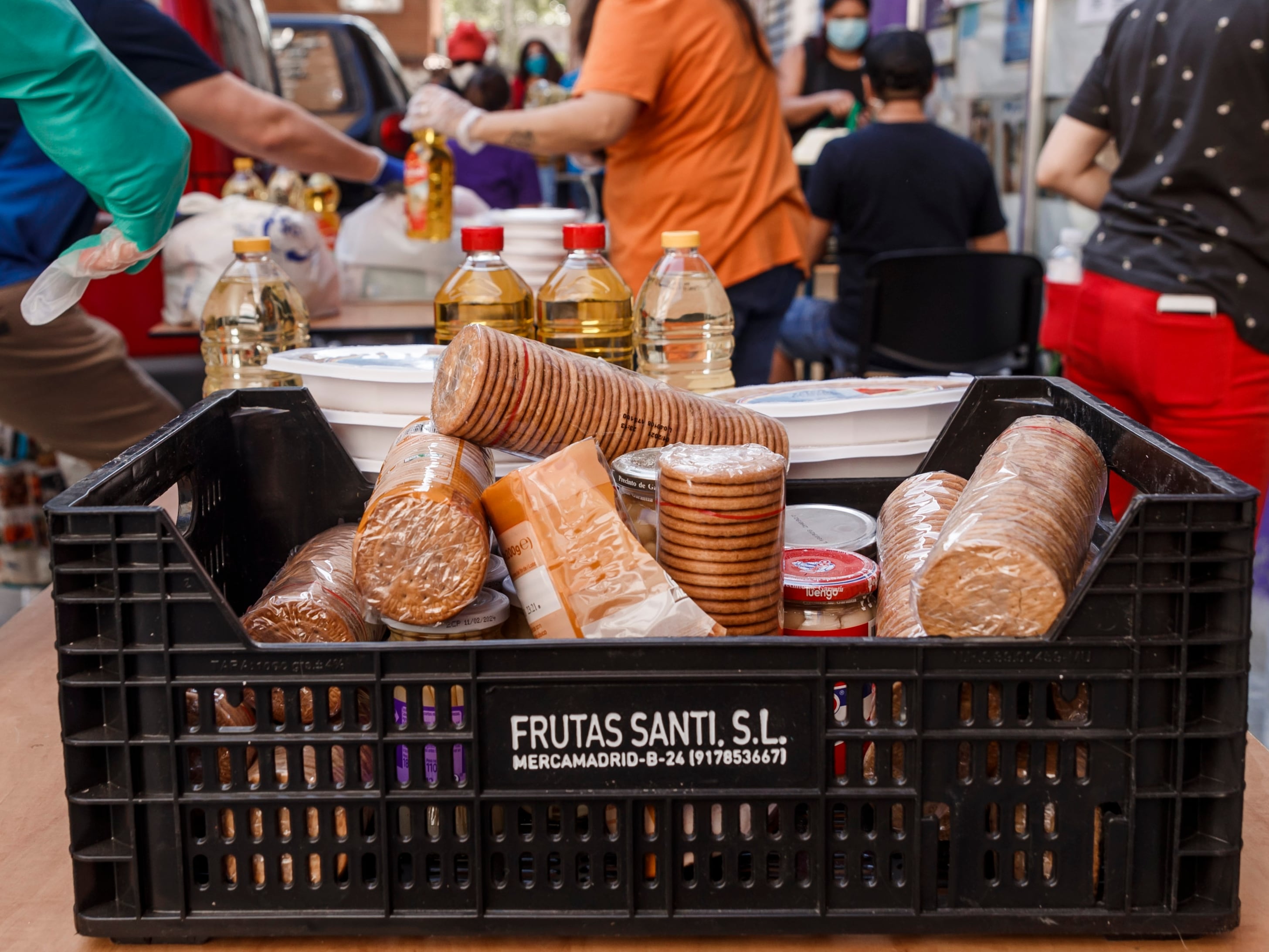 Voluntarios cargan cajas con alimentos no perecederos básicos para repartirlos entre familias sin recursos durante la pandemia