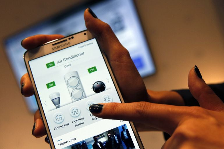 An employee demonstrates using the air conditioner control function of the Samsung Smart Home system with a smartphone at the Samsung Innovation Museum, operated by Samsung Electronics Co., in Suwon, South Korea, on Wednesday, Nov. 5, 2014. Anticipation f