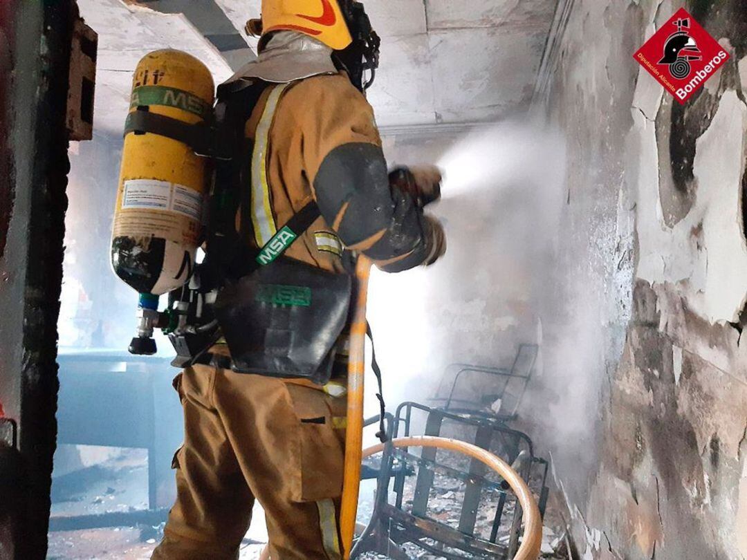 Bomberos sofocando el fuego iniciado en una nave industrial abandonada en Elda 