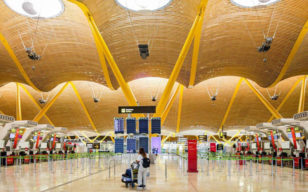 Una turista observa los paneles de la Terminal 4 del Aeropuerto Adolfo. Los viajes no imprescindibles a países de UE o del espacio Schengen seguirán restringidos hasta el 15 de mayo.
