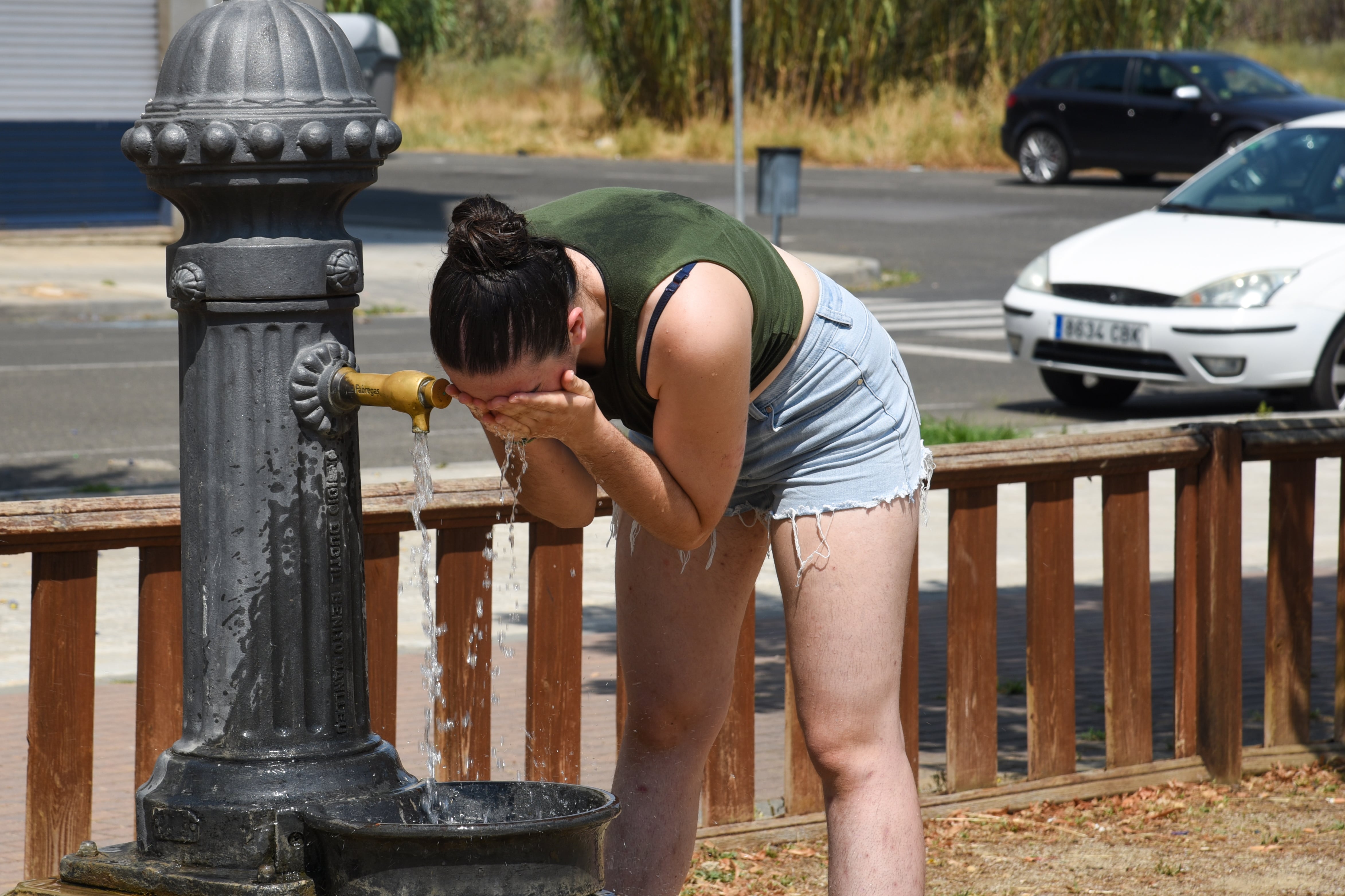 15/07/2022.-Una joven se refresca en un fuente de un parque de Lleida.EFE/Ramon Gabriel